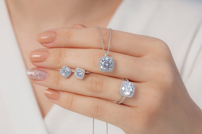 A woman holding white gold rings and a white gold necklace in her hand 