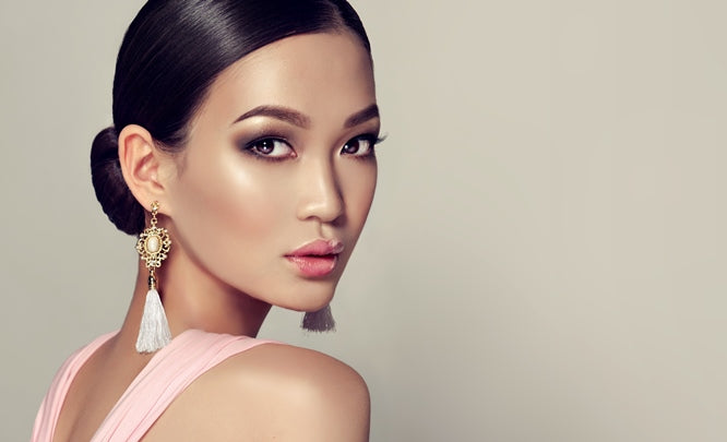 Asian model wearing high fashion, luxurious tassel earrings with a pink dress